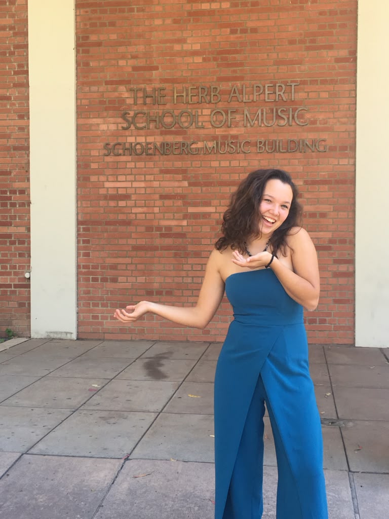 Gabriela Beltrán smiling in a teal outfit outside the Herb Alpert School of Music