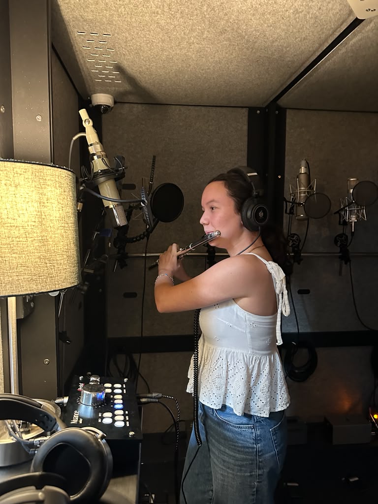 Gabriela Beltrán recording flute in a professional studio with microphones and headphones