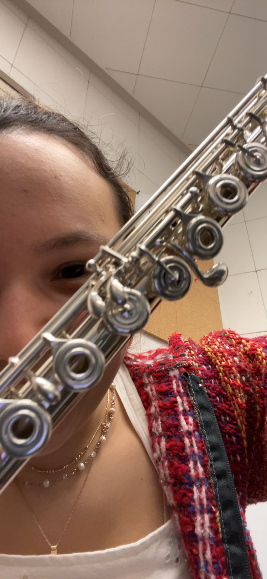 Close-up of Gabriela Beltrán's face behind the keys of her silver flute